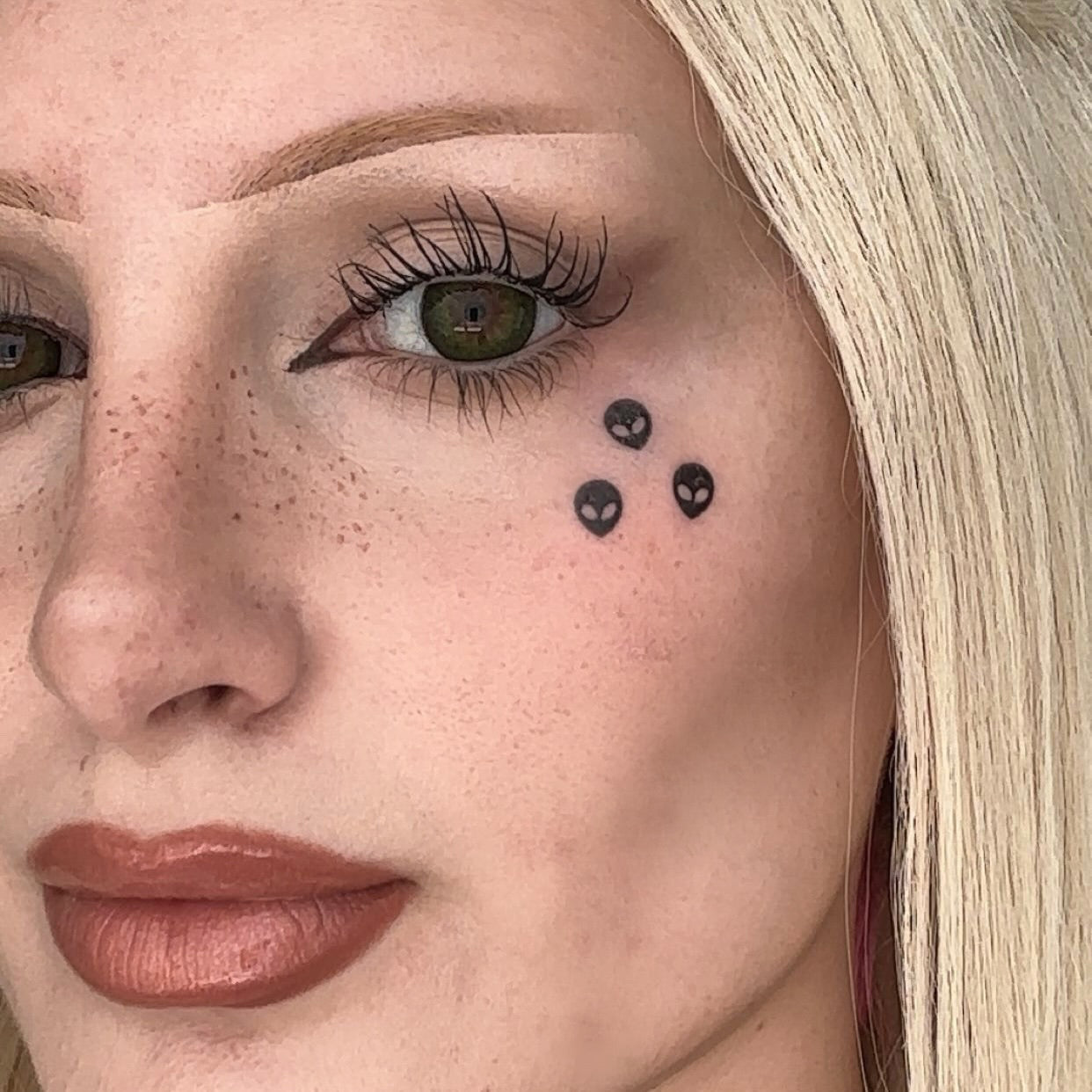 Black alien design stamp used in a graphic makeup look