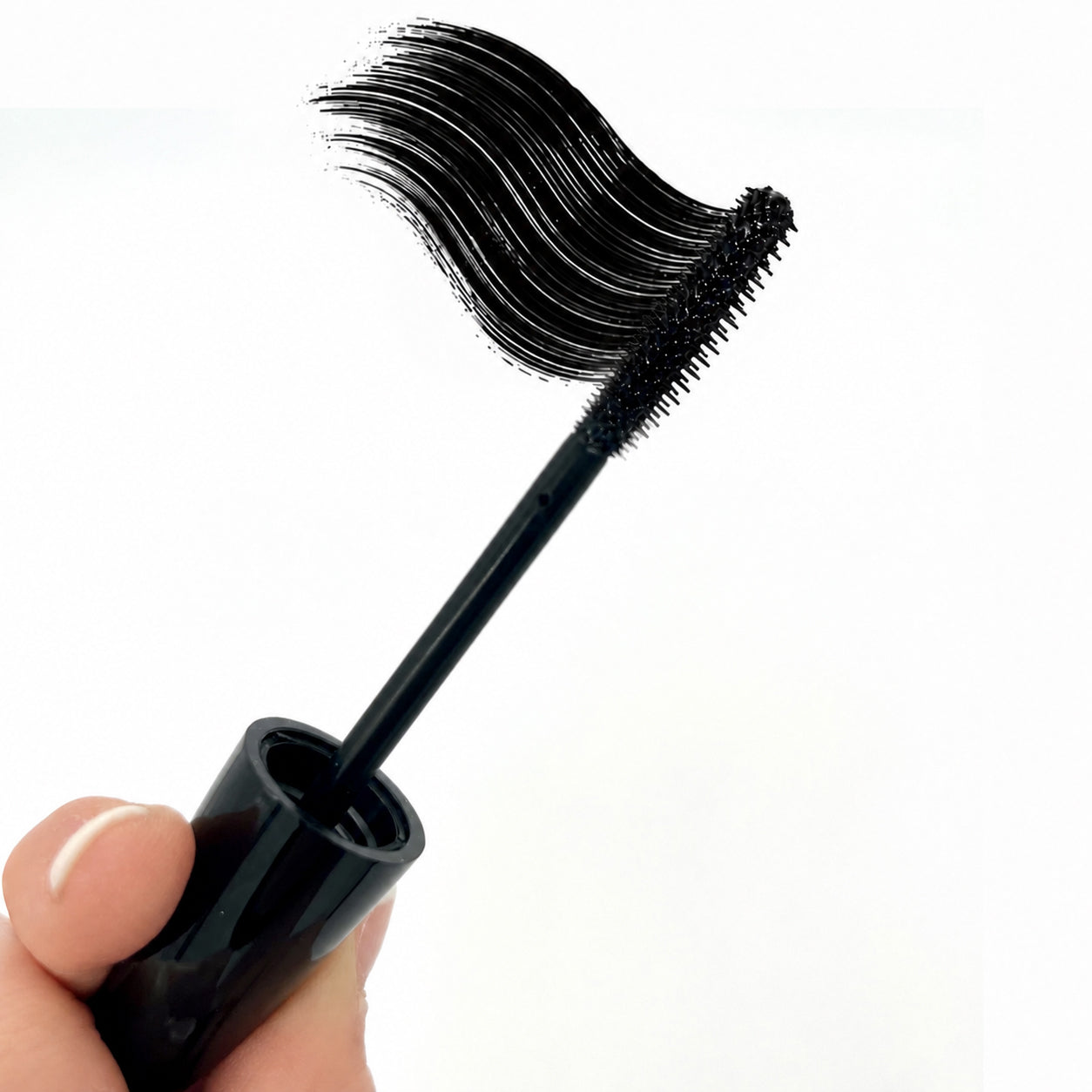 Black Sunset Makeup mascara wand with a curved black formula swatch, held above the open cap against a white background.