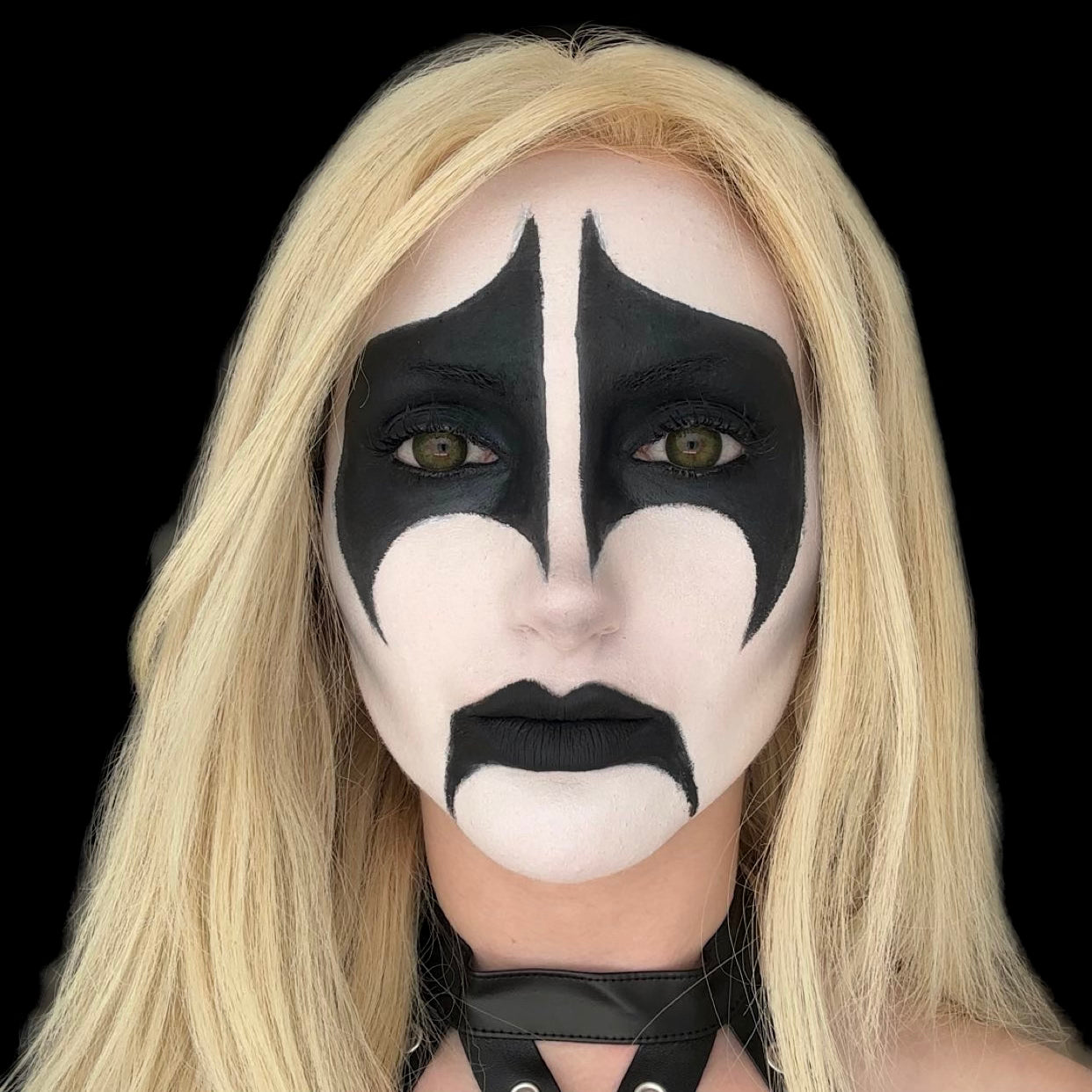 Woman wearing a dramatic black and white corpse paint makeup look created with Sunset Makeup products.