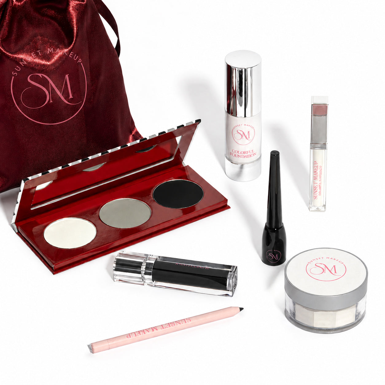 Sunset Makeup Goth Bundle Grand Edition makeup gift set with seven goth makeup essentials for a white base, black lips, eyeliner, highlighting, and contouring, arranged with a satin burgundy pouch.